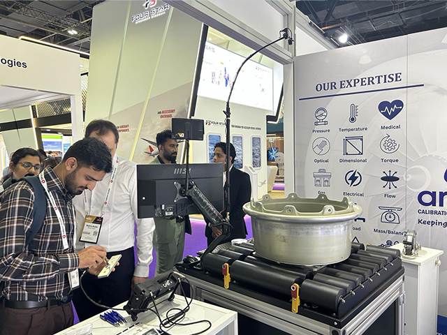 Посетитель стенда OKOndt GROUP работает с роторным сканером болтовых отверстий, выставка ТОиР в авиации, Дубай, 2026